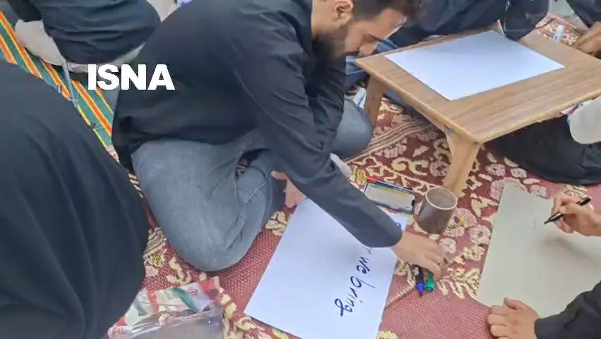 پلاکارد‌ نویسی برای عزاداران به دو زبان فارسی و انگلیسی در خیابان کارگر جنوبی + فیلم
