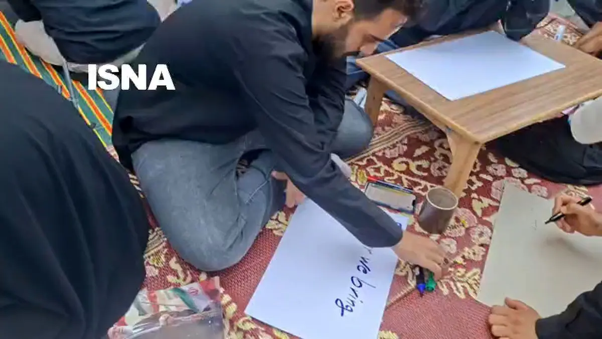 پلاکارد‌ نویسی برای عزاداران به دو زبان فارسی و انگلیسی در خیابان کارگر جنوبی + فیلم