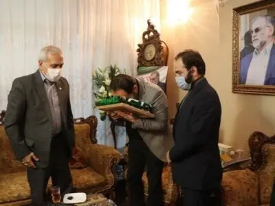 اهدای پرچم آستان رضوی به خانواده دانشمند شهید دکترفخری زاده