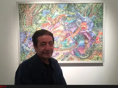 هنرمندی که با قلم‌نی، نقاشی می‌کند