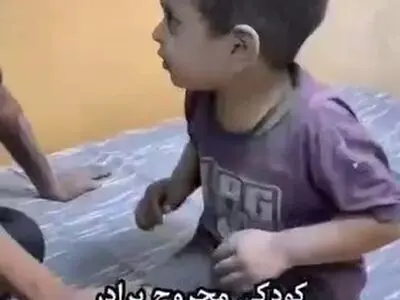 دلداری دادن کودکی مجروح به برادر خردسالش پس از شهادت والدینشان در نوار غزه + فیلم