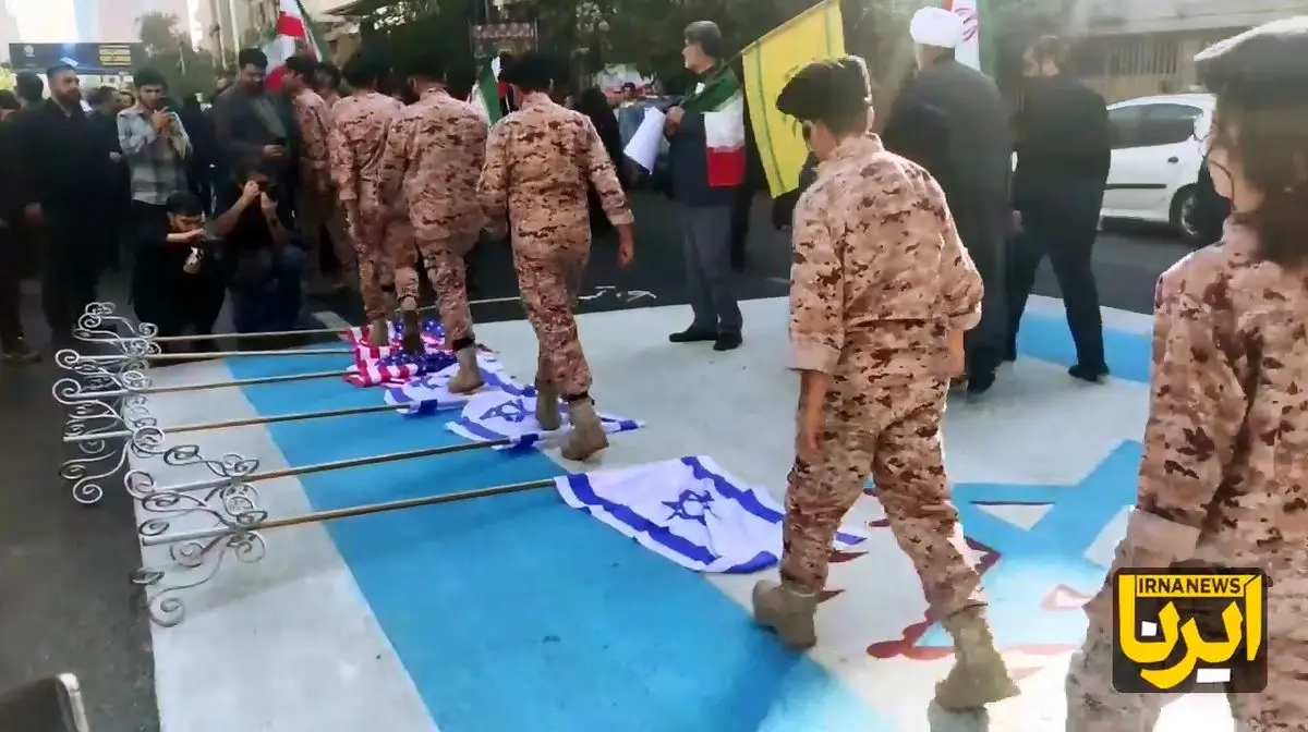 عبور دانش‌آموزان با لباس رزم از روی پرچم آمریکا و رژیم صهیونی + فیلم